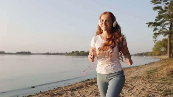 Ung leende kvinna med rött lockigt hår gör kväll sport övningar. — Stockvideo