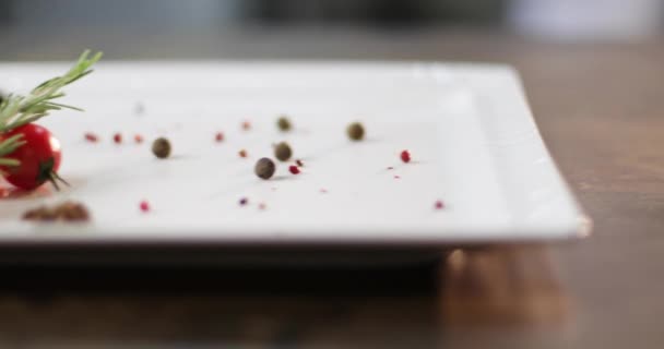 Bílý talíř s kořením, pepřem a cherry rajčaty. — Stock video
