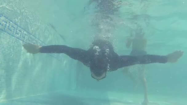 En man simmar under vattnet i poolen. — Stockvideo