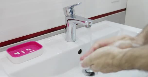 Закрыть лицо, когда мужчина моет руки теплой водой.. — стоковое видео