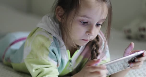 Un niño está mirando en un teléfono celular. — Vídeo de stock