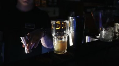 Barmen portakal kokteyline bir bardak votka koyar.. 