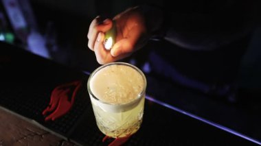 Barmen bir kokteyl için tarçın serpiştirir ve ateşe verir.. 