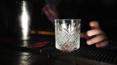 Barmen eleğe süt döker ve bardağa doldurur..