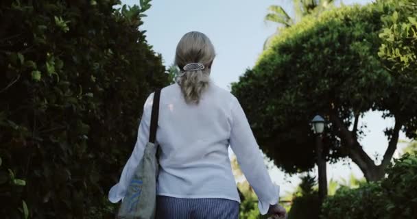Una anciana camina en el verano al aire libre. — Vídeos de Stock