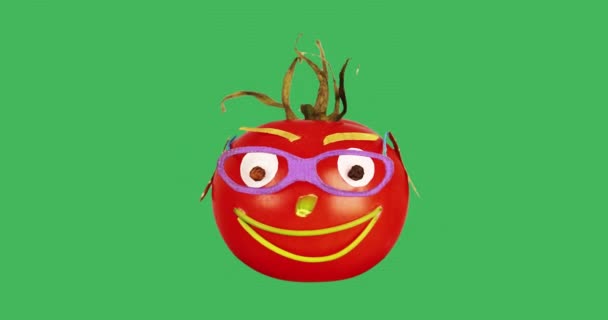 Gözlüklü neşeli bir domates yeşil bir arka planda döner.. — Stok video