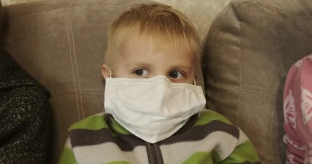Duża rodzina siedzi w maskach medycznych podczas epidemii na świecie. — Wideo stockowe
