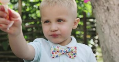 Küçük kız kameraya bakarken lolipopun tadını çıkarıyor.. 