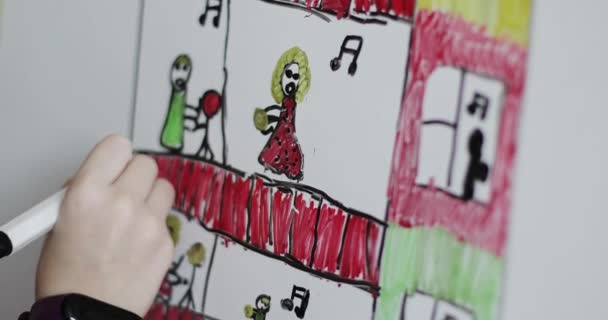 Ребёнок крупным планом рисует дом с музыкантами на балконе. — стоковое видео