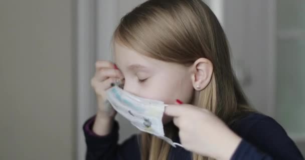 Bebê bonito coloca uma máscara médica protetora. — Vídeo de Stock