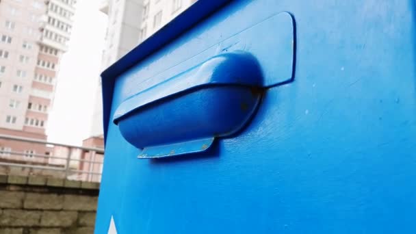 Ett barn i handskar kastar ett brev i en blå brevlåda. — Stockvideo