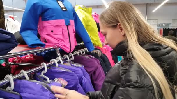 Kobieta wybiera ubrania w sklepie. Zakupy. — Wideo stockowe