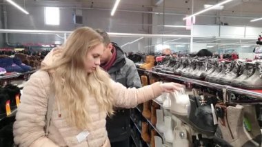 Bir erkek ve bir kadın mağazadan ayakkabı seçerler.. 