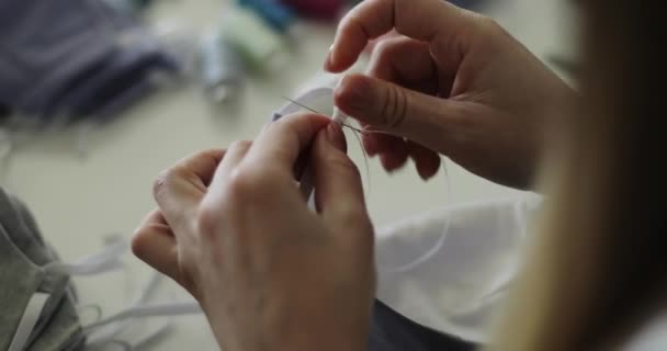 Primo piano delle mani femminili cucire maschere mediche. — Video Stock