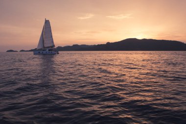 Yat - Katamaran Okyanusu. Gün batımında yelken