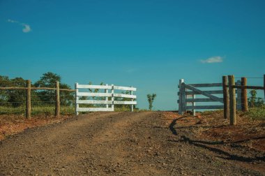 Farm gate with cattle guard and barbed wire fence clipart
