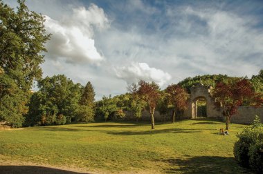 Gün batımında bitki örtüsünün ortasında duvar ve kapı