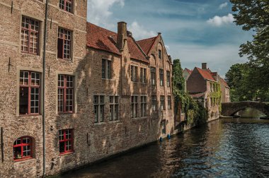 Bruges kanalında bahçeler ve tuğla binalar