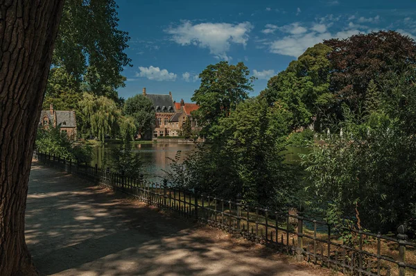 Chemin au milieu de verdure avec lac et vieux bâtiment en brique à Bruges — Photo