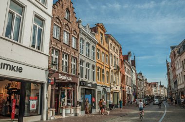 Bruges'te insanlarla, tuğla evlere ve dükkanlarla sokak