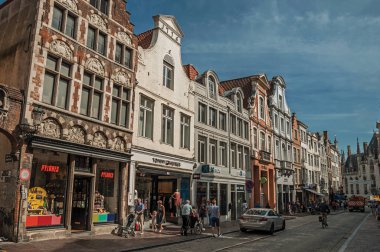 Bruges'te insanlarla, tuğla evlere ve dükkanlarla sokak