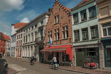 Bruges'te insanlarla, tuğla evlere ve dükkanlarla sokak