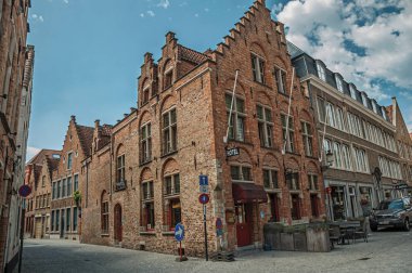 Bruges'te boş sokakta tuğla binalar ve mavi gökyüzü