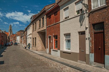 Bruges sokakta eski tuğla evler ve çan kulesi