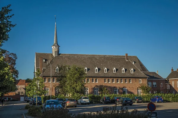 Edificio de ladrillo y estacionamiento al atardecer en Tielt — Foto de Stock