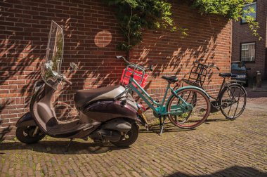 Weesp tuğladuvar önünde Bisiklet ve scooter