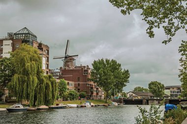 Amsterdam'da modern tuğla binalar ve demirli tekneler ile Kanal