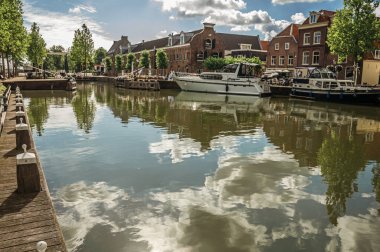 Weesp'te kanal su yüzeyine yansıyan bulutlar ve ağaç