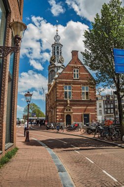 Amsterdam'da insanlarla, tuğla binalarla ve çan kulesiyle sokak
