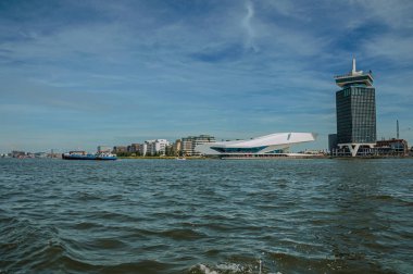 Amsterdam kanalı üzerinde gemi ve modern binalar