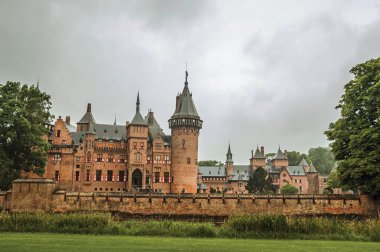 De Haar Castle with ornate brick towers and lawn wooded gardens clipart