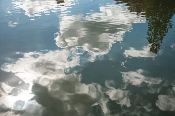 Nubes y árboles reflejados en la superficie del agua del canal — Foto de Stock