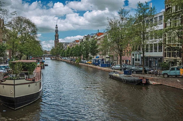 Kanál se starými cihlovými budovami a kotvími loděmi v Amsterdamu — Stock fotografie