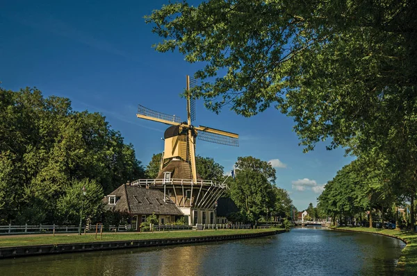 Dom i drewniany żółty wiatrak obok kanału w Weesp — Zdjęcie stockowe