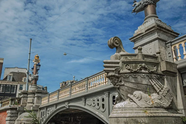 Puente de piedra con escultura de arco de barco en Amsterdam — Foto de Stock
