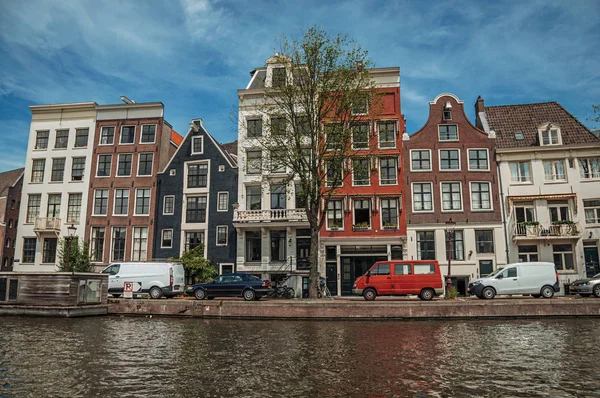 Канал со старыми кирпичными зданиями рядом с улицей Амстердама — стоковое фото
