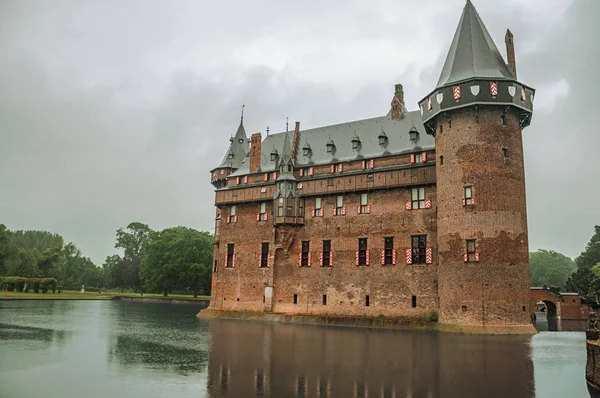 A de Haar kastély homlokzata tégla tornyokkal és várárok esős napon — Stock Fotó