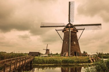 Kinderdijk bulutlu bir günde çalılar ve yel değirmenleri ile Kanal