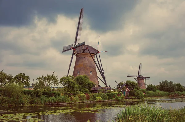 Kinderdijk bulutlu bir günde çalılar ve yel değirmenleri ile Kanal