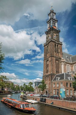 Amsterdam'da eski tuğla çan kulesi kilise ve tekneler ile Kanal