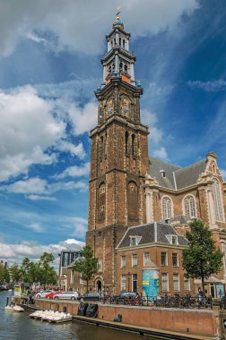 Amsterdam'da eski tuğla çan kulesi kilise ve tekneler ile Kanal