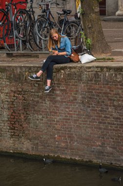 Amsterdam 'da dondurmayla kanal kenarında genç bir kız.