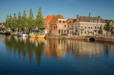 Weesp gün batımında tuğla evler ve demirli tekneler ile Kanal