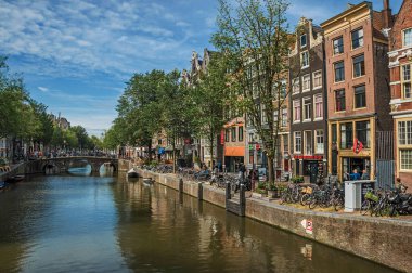 Amsterdam'da eski tuğla binalar, köprü ve tekneler ile Kanal