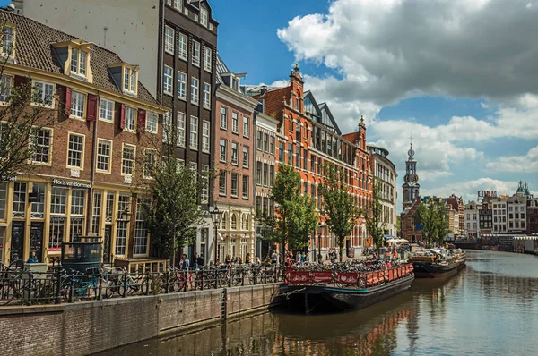 Kanaal met typische huizen en afgemeerde boten in Amsterdam — Stockfoto