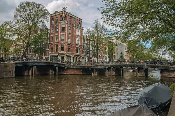 Canal com edifícios de tijolos antigos e ponte em Amsterdã — Fotografia de Stock